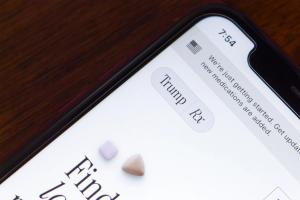 Angled close-up of TrumpRx logo on its website is seen in an iPhone. | © koshiro k - stock.adobe.com (1916047981)
