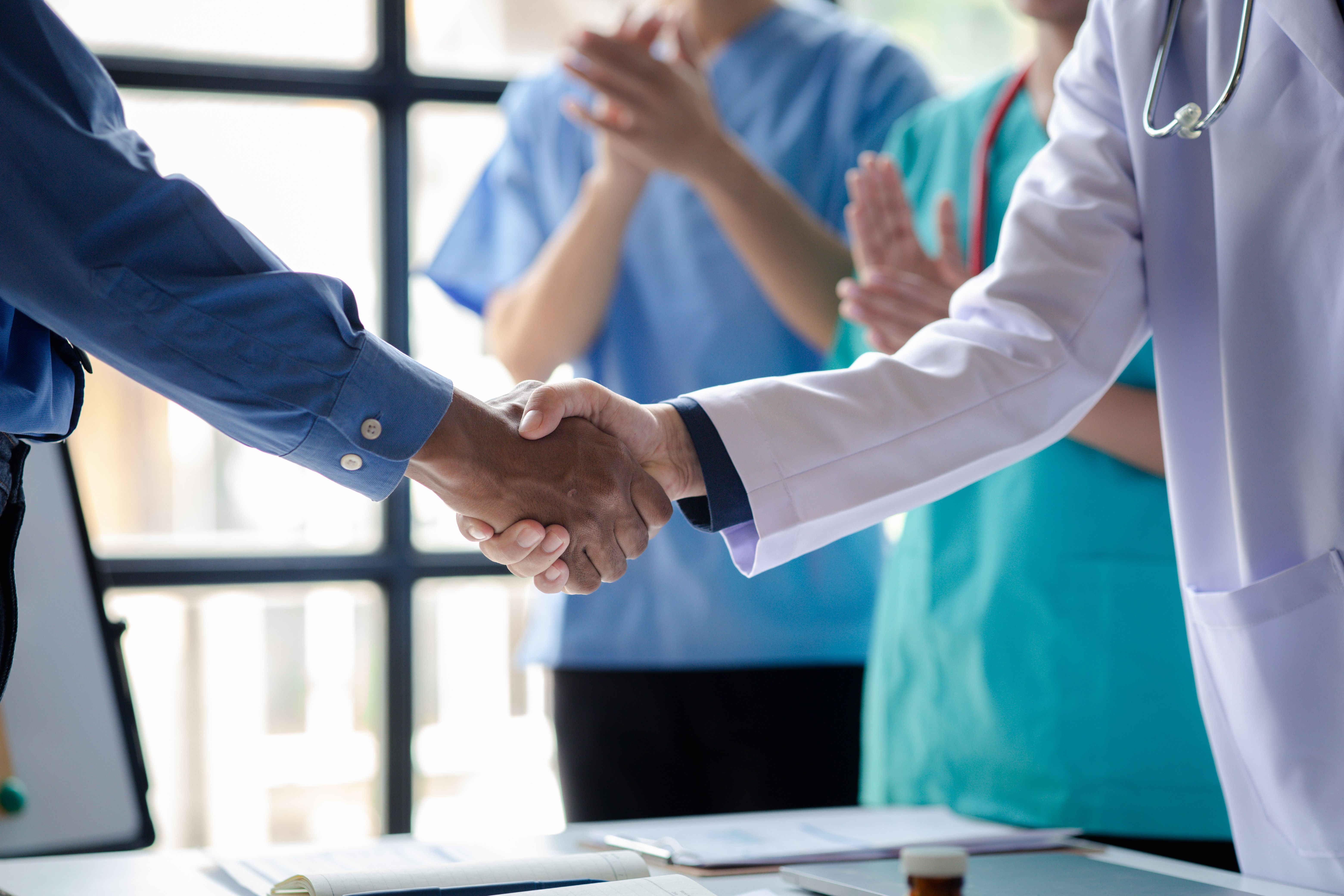 Conference room in the hospital, a group of doctors attending a handshake meeting, a meeting of executive doctors and chiefs meeting with pharmaceutical dealers. Doctor meeting concept. | © kamiphotos - stock.adobe.com