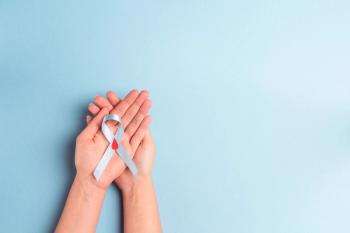 Helping hands holding blue ribbon awareness with red blood drop on a blue background. World diabetes day,14 november - Image credit: WindyNight | stock.adobe.com