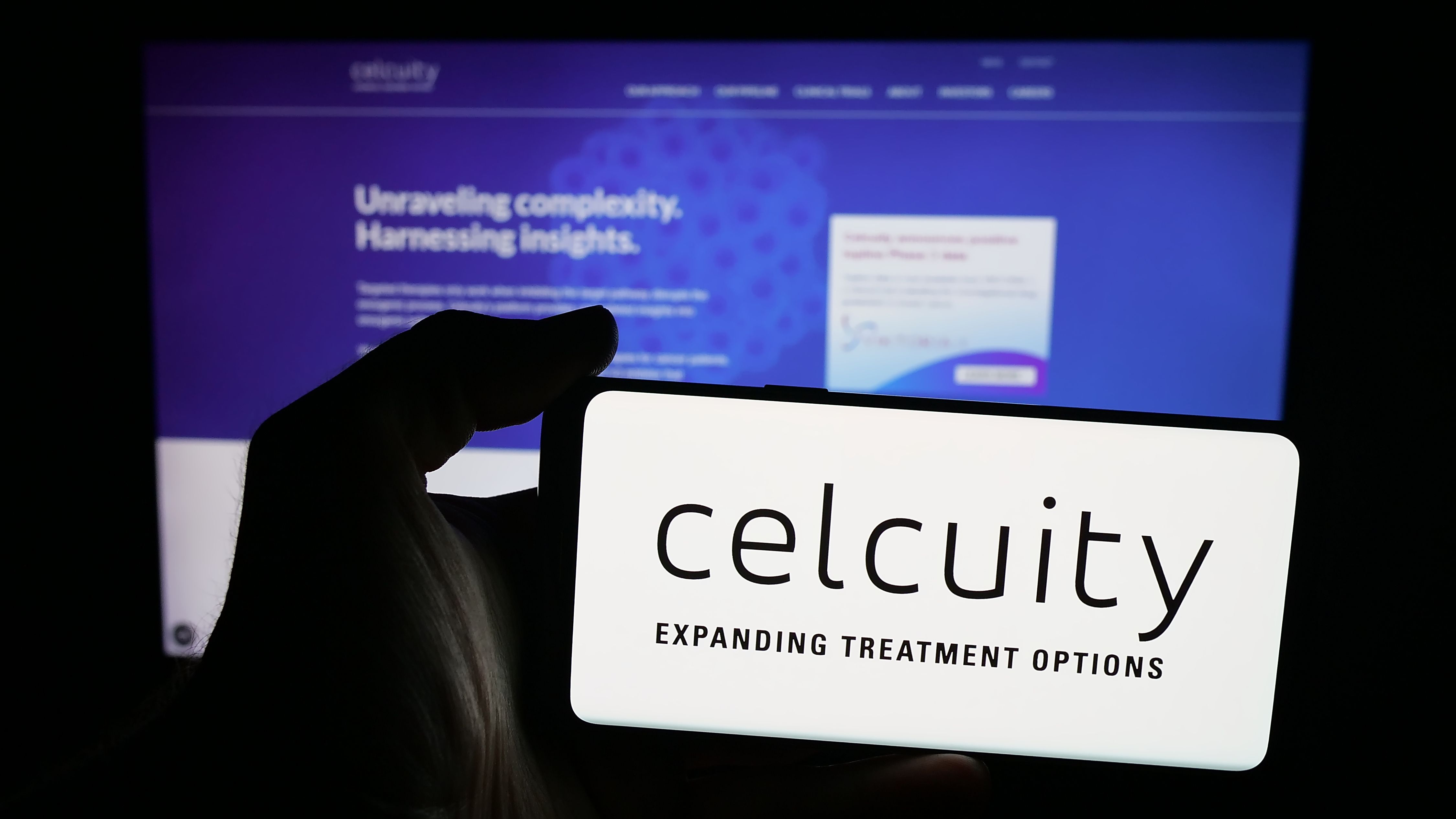 Stuttgart, Germany - 08-28-2025: Person holding mobile phone with logo of US biotechnology company Celcuity Inc. on screen in front of web page. Focus on phone display. | Image Credit: Timon | stock.adobe.com