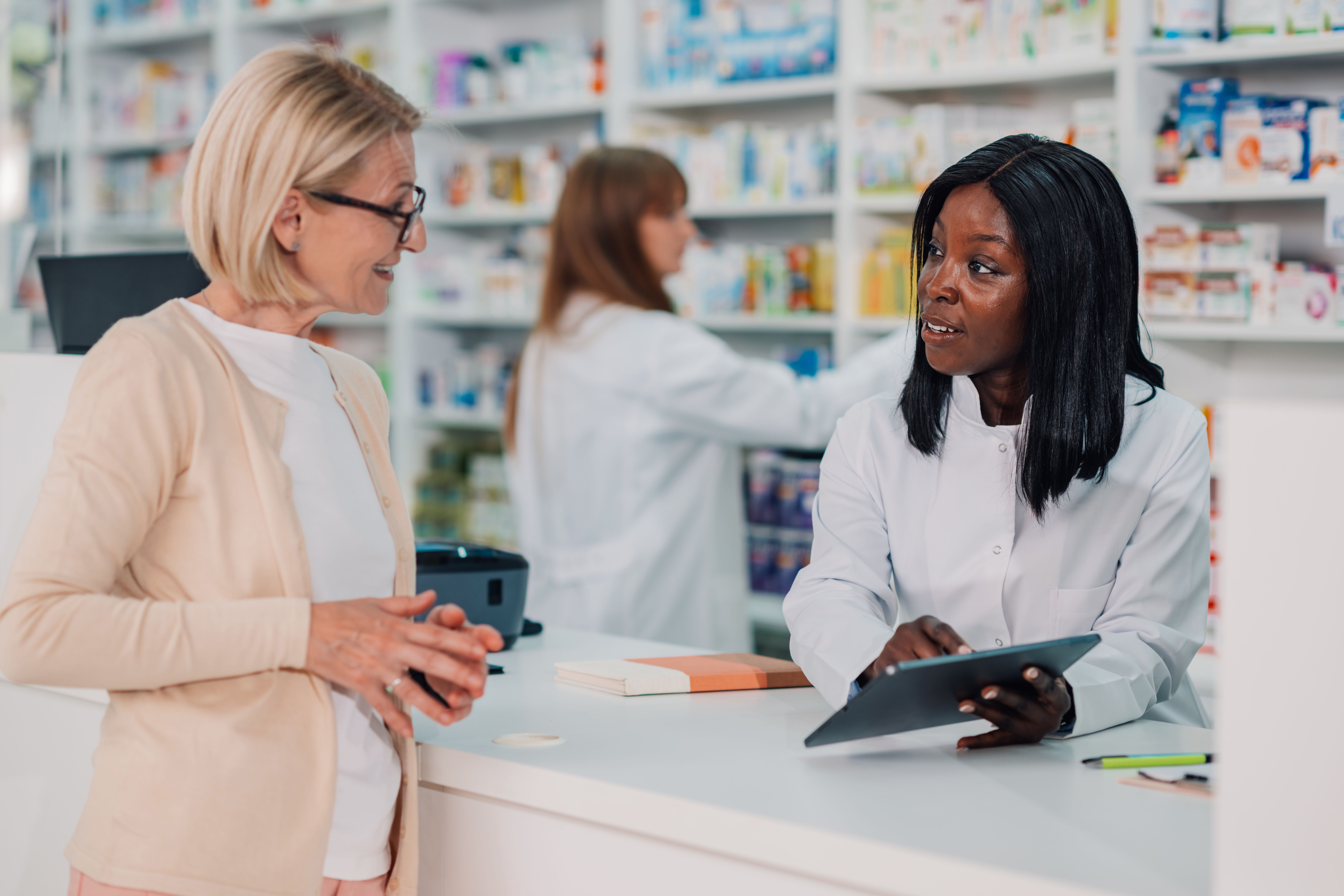 Pharmacist and patient in a community pharmacy -- Image credit: Zamrznuti tonovi | stock.adobe.com