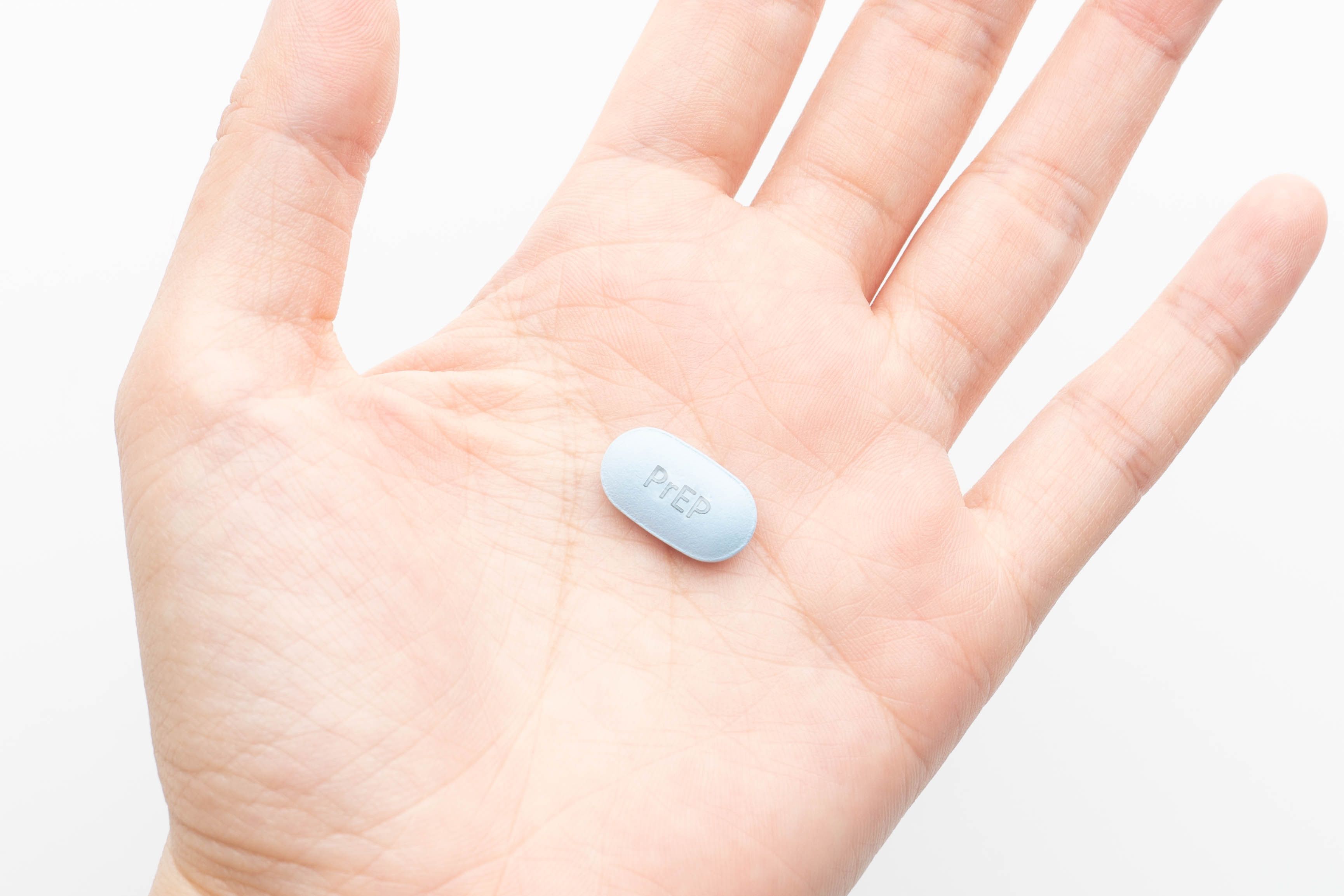 Woman holding dose of oral PrEP