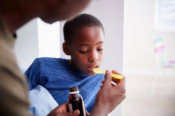 Father Giving Sick Son Ill In Bed Medicine From Bottle- Image credit: Monkey Business | stock.adobe.com