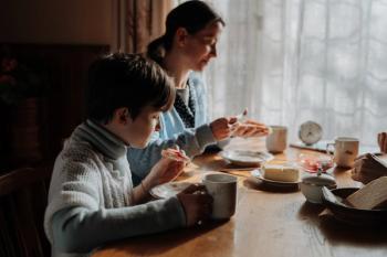 Family having simple meal together, eating bread with jam.