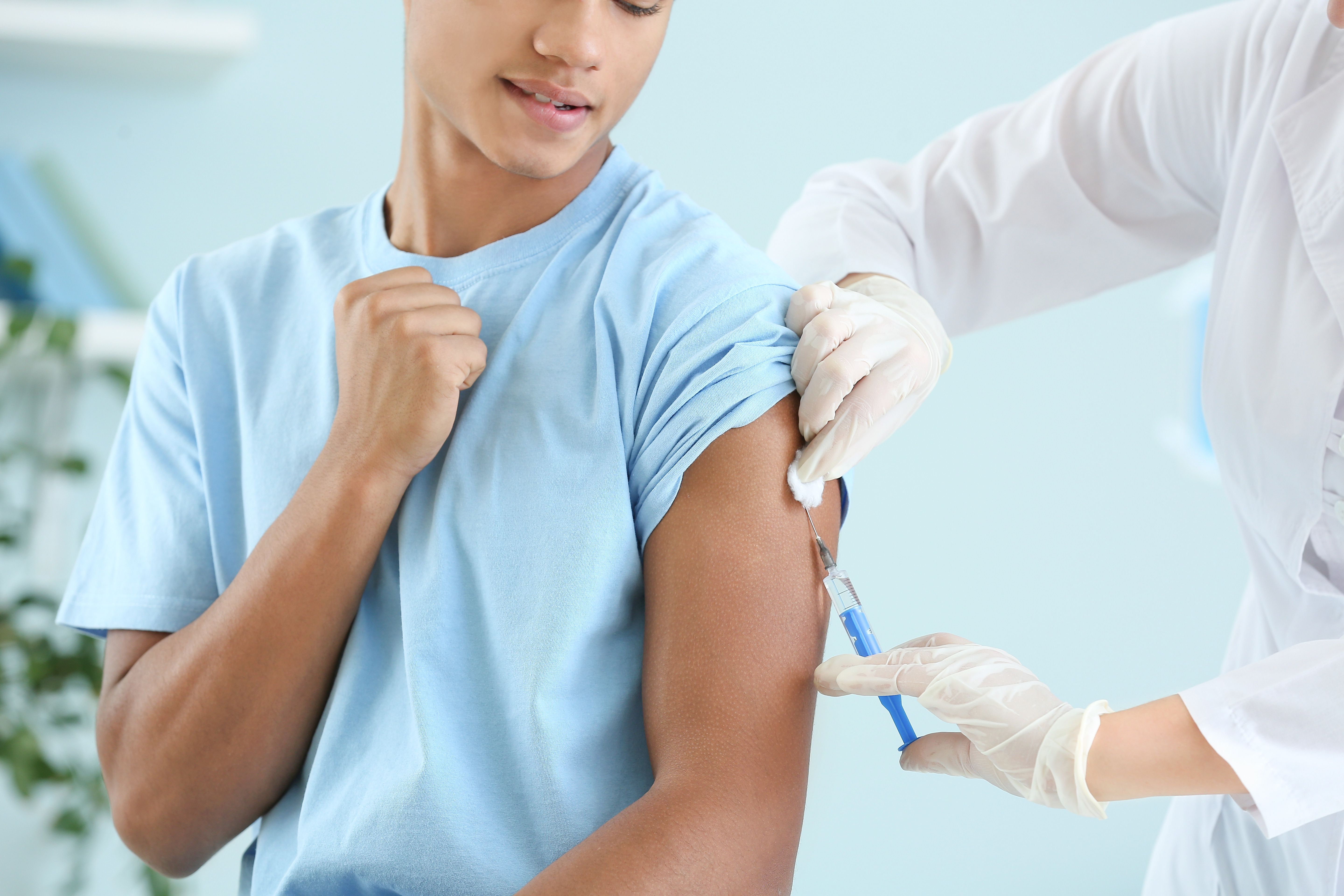 Doctor vaccinating teenage boy in clinic | Image credit: Pixel-Shot - stock.adobe.com