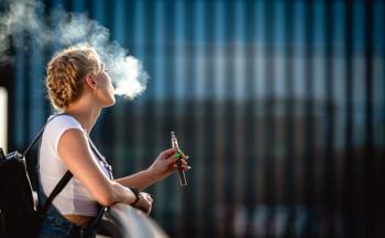 Young woman outdoor vaping e-cigarette on modern city buildings background | Image Credit: leszekglasner - stock.adobe.com
