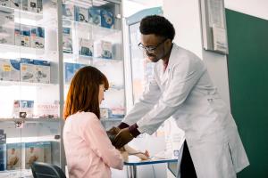Pharmacist helping patient measure their blood pressure -- Image credit: sofiko14 | stock.adobe.com