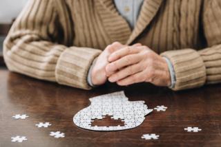 Cropped view of senior man playing with puzzles on table- Image credit: LIGHTFIELD STUDIOS | stock.adobe.com
