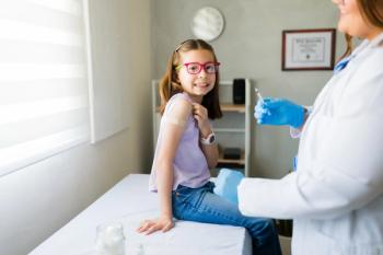 Young girl smiling after receiving a vaccine from a pediatrician in a doctor's office, showing confidence and healthcare