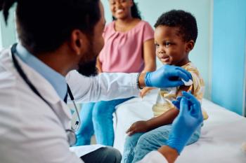 Smiling boy receiving vaccine at pediatrician's office. | Image Credit: Drazen | stock.adobe.com
