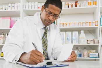Pharmacist writing on a clipboard -- Image credit: moodboard | stock.adobe.com