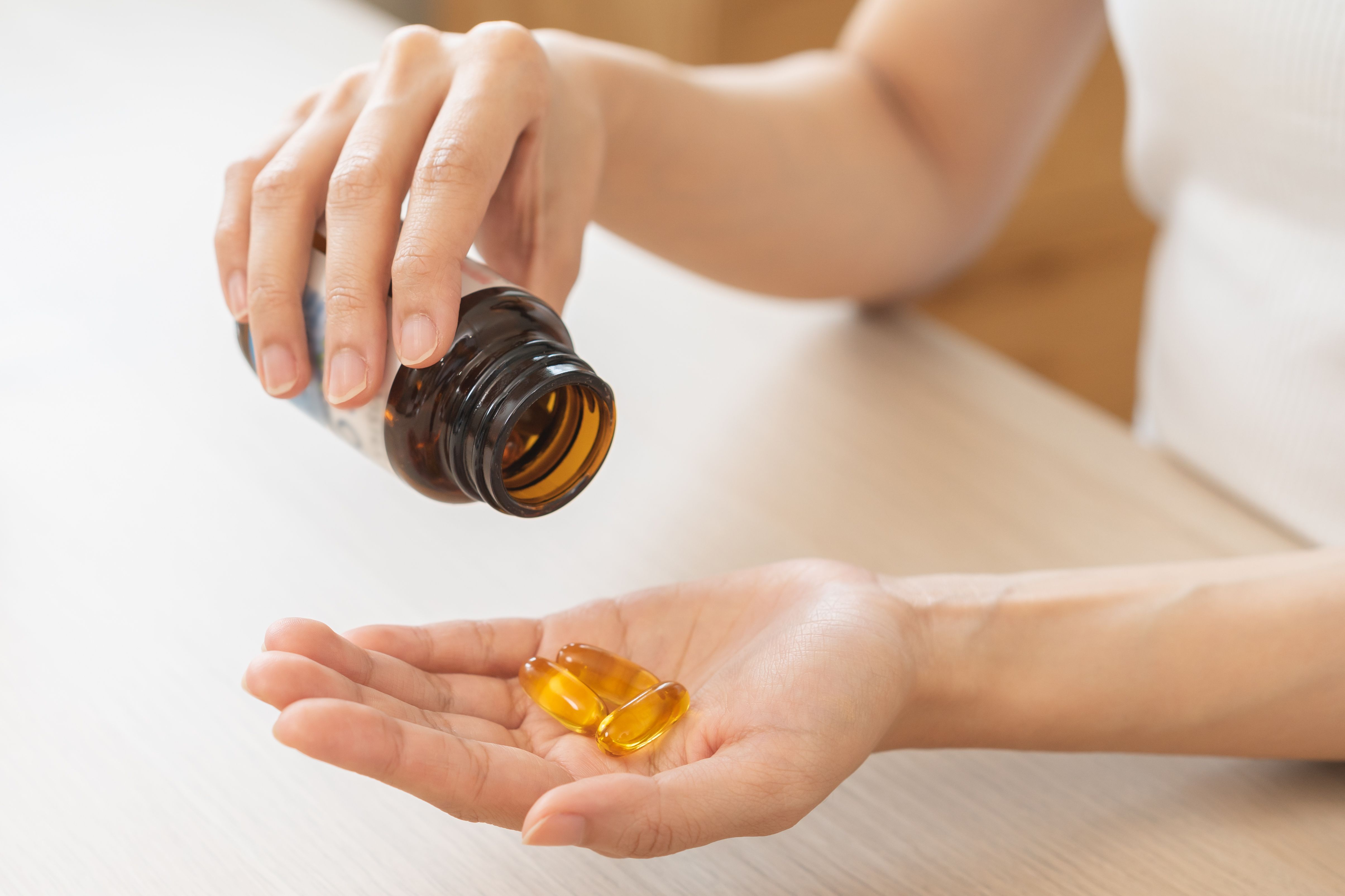 Woman holding vitamin D supplements