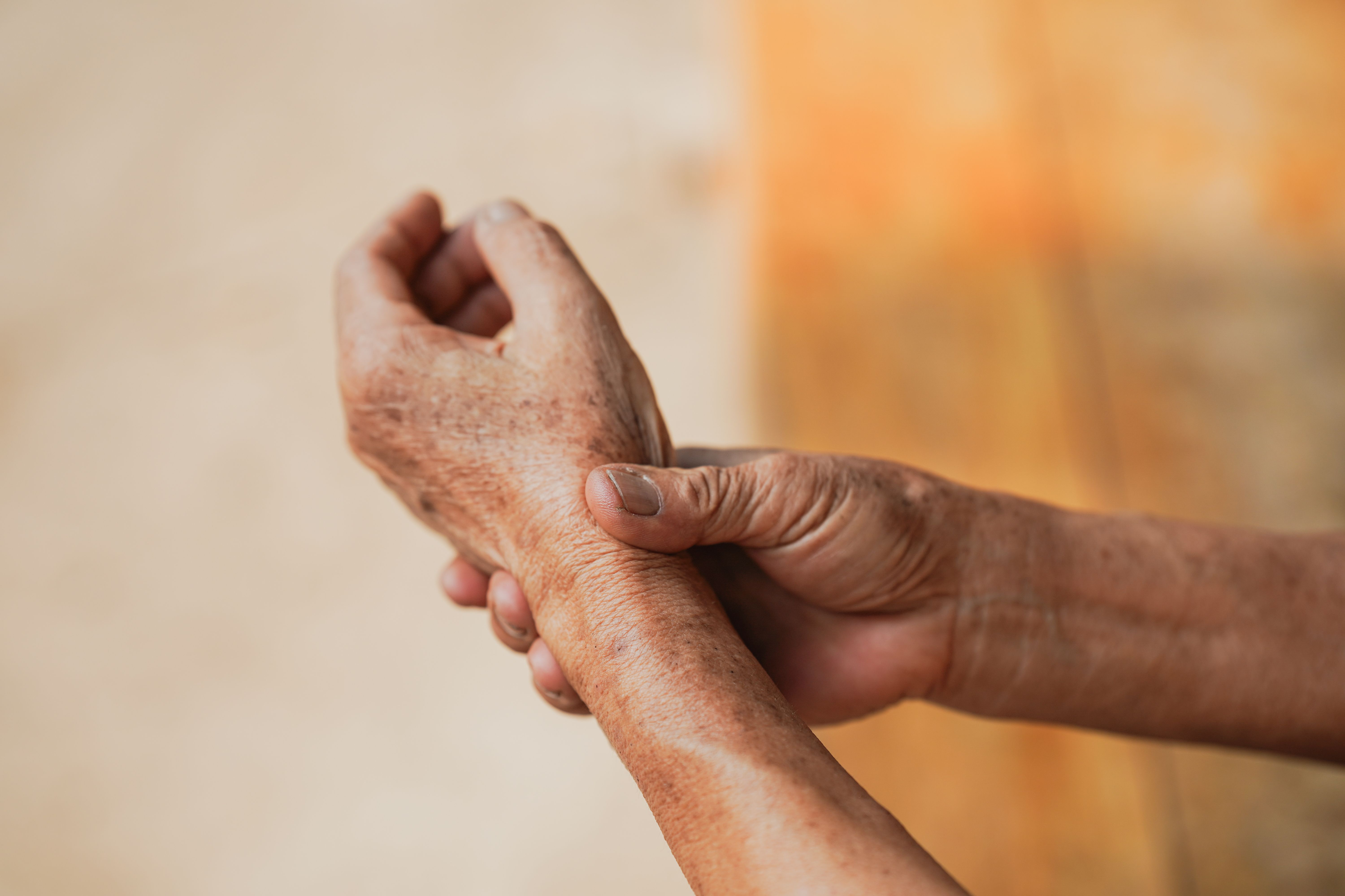Older woman holding her painful wrist. | Image Credit: Oporty786 | stock.adobe.com