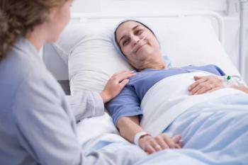 Female patient in hospital being comforted by health care worker