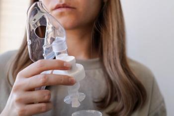 Woman holding breathing inhaler, nebulizer, in hand preparing for home procedure, treatment of cold in sick season.