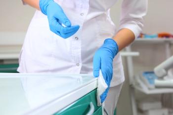 Health care professional wiping down contaminated surface -- Image credit: Alla | stock.adobe.com