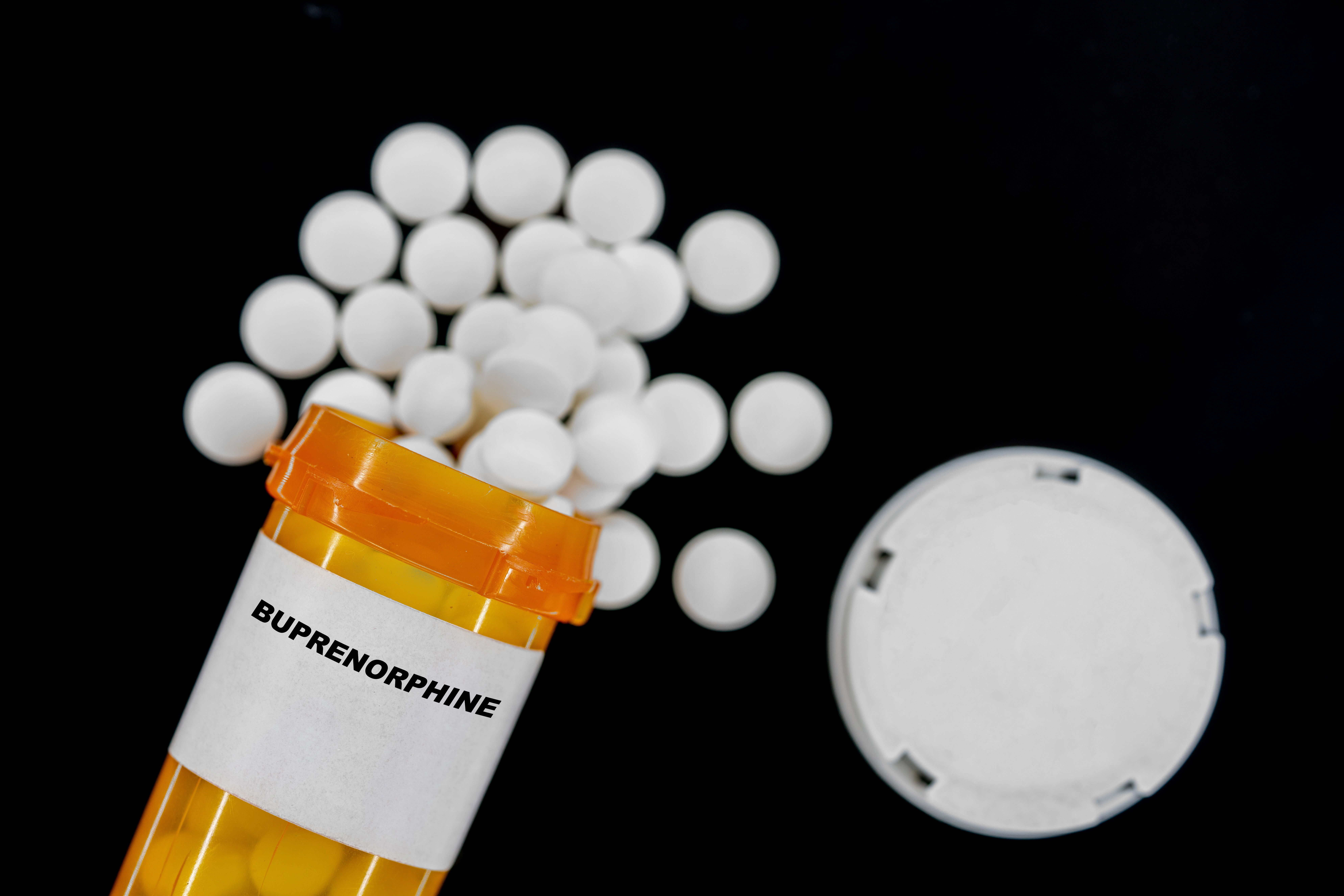 Buprenorphine Rx medical pills in plactic Bottle with tablets. Pills spilling out from yellow container. | Image Credit: luchschenF | stock.adobe.com