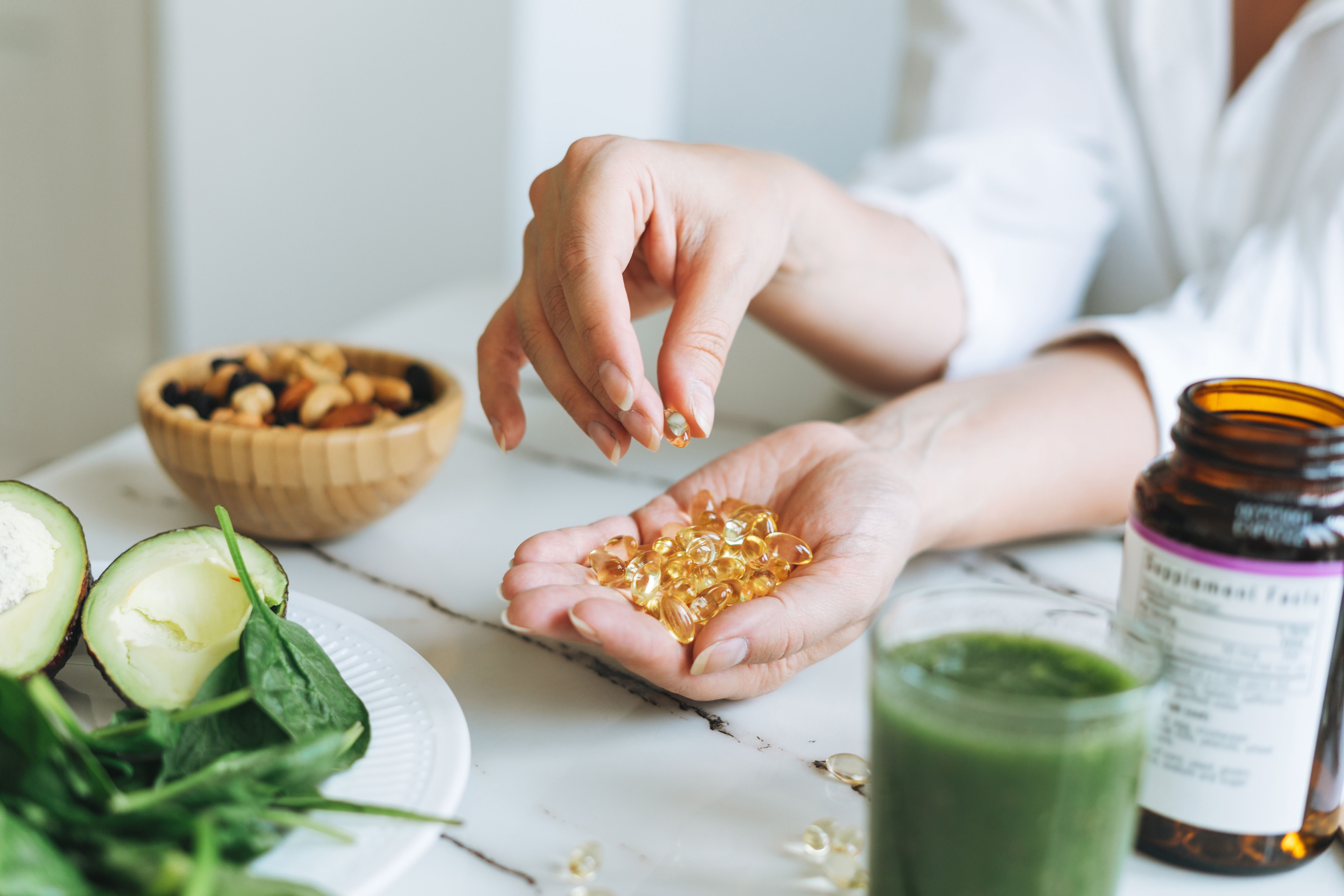 Doctor nutritionist hands in white shirt with omega 3, vitamin D capsules with green vegan food. The doctor prescribes a prescription for medicines and vitamins at clinic | Image Credit: Galina Zhigalova | stock.adobe.com Doctor nutritionist hands in white shirt with omega 3, vitamin D capsules with green vegan food. The doctor prescribes a prescription for medicines and vitamins at clinic | Image Credit: Galina Zhigalova | stock.adobe.com