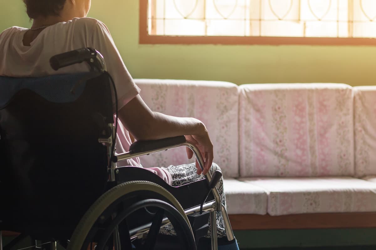 senior or elderly old lady woman patient on wheelchair looking out the window so sad at home