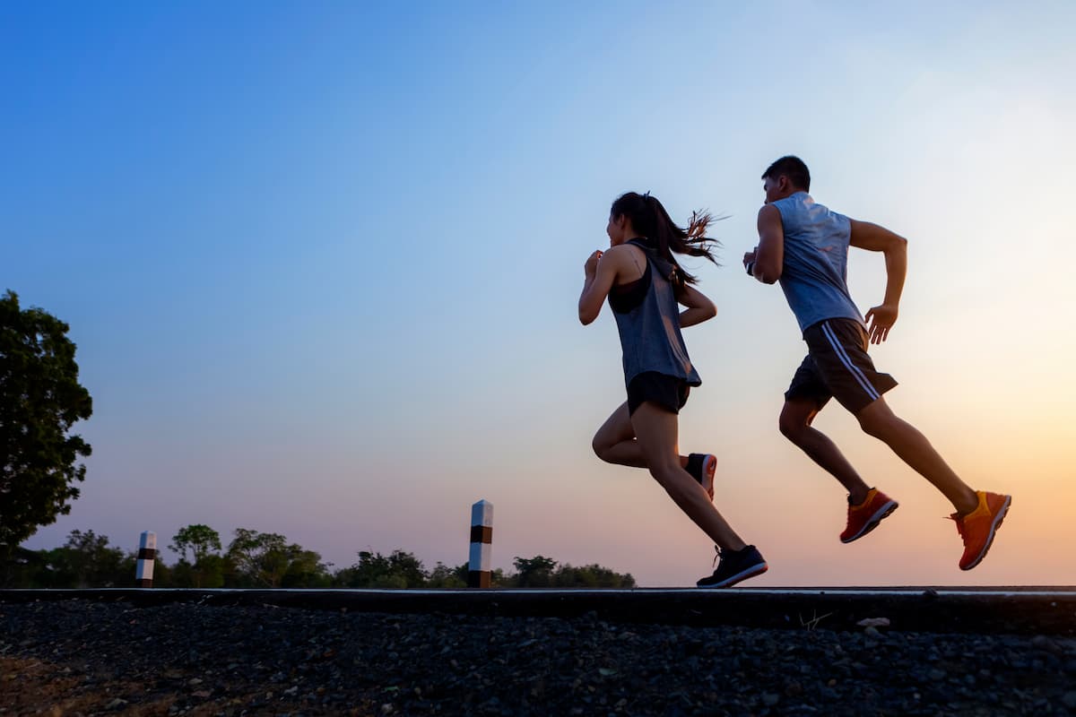 Running at sunrise couple exercising for marathon and workout .fitness, sport, people and lifestyle concept - Happy couples exercising with outdoor running