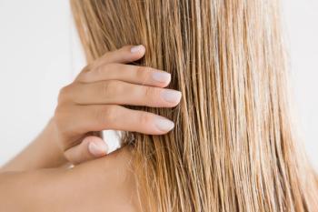Young woman with hand touching her wet hair- Image credit: fotoduetsm | stock.adobe.com