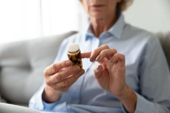 Elderly woman holding a prescription bottle