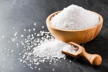 Salt in wooden bowl on dark stone table. | Image Credit: Milan - stock.adobe.com