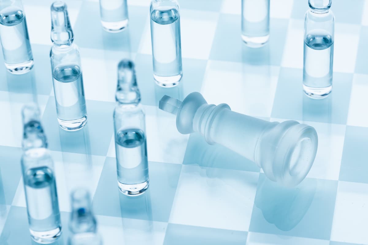 Vaccine for the virus. Medical ampoules on a chessboard, defeat the king. Concept cure for coronavirus.