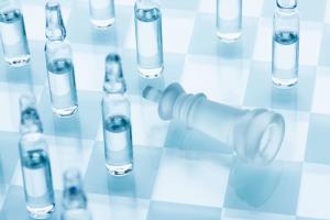 Vaccine for the virus. Medical ampoules on a chessboard, defeat the king. Concept cure for coronavirus.