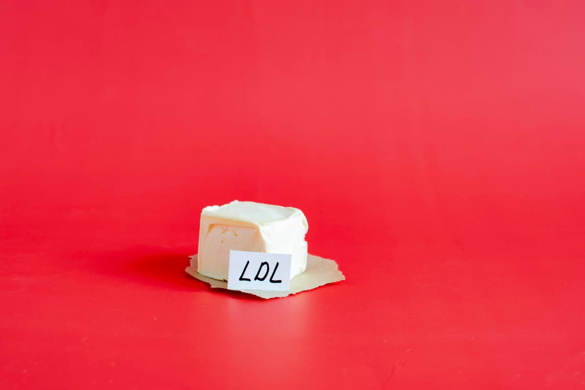 A piece of margarine in close-up on a red background and the inscription low-density lipoproteins ldl