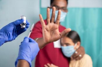 Selective focus on coronavirus vaccination bottle - Concept of Parents vaccine hesitancy for children, showing by saying no or stop gesture to vaccine with hand at hospital - Image credit: WESTOCK | stock.adobe.com
