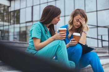 Women doctors talking over coffee on hospital steps | Image Credit: © Dragana Gordic - stock.adobe.com