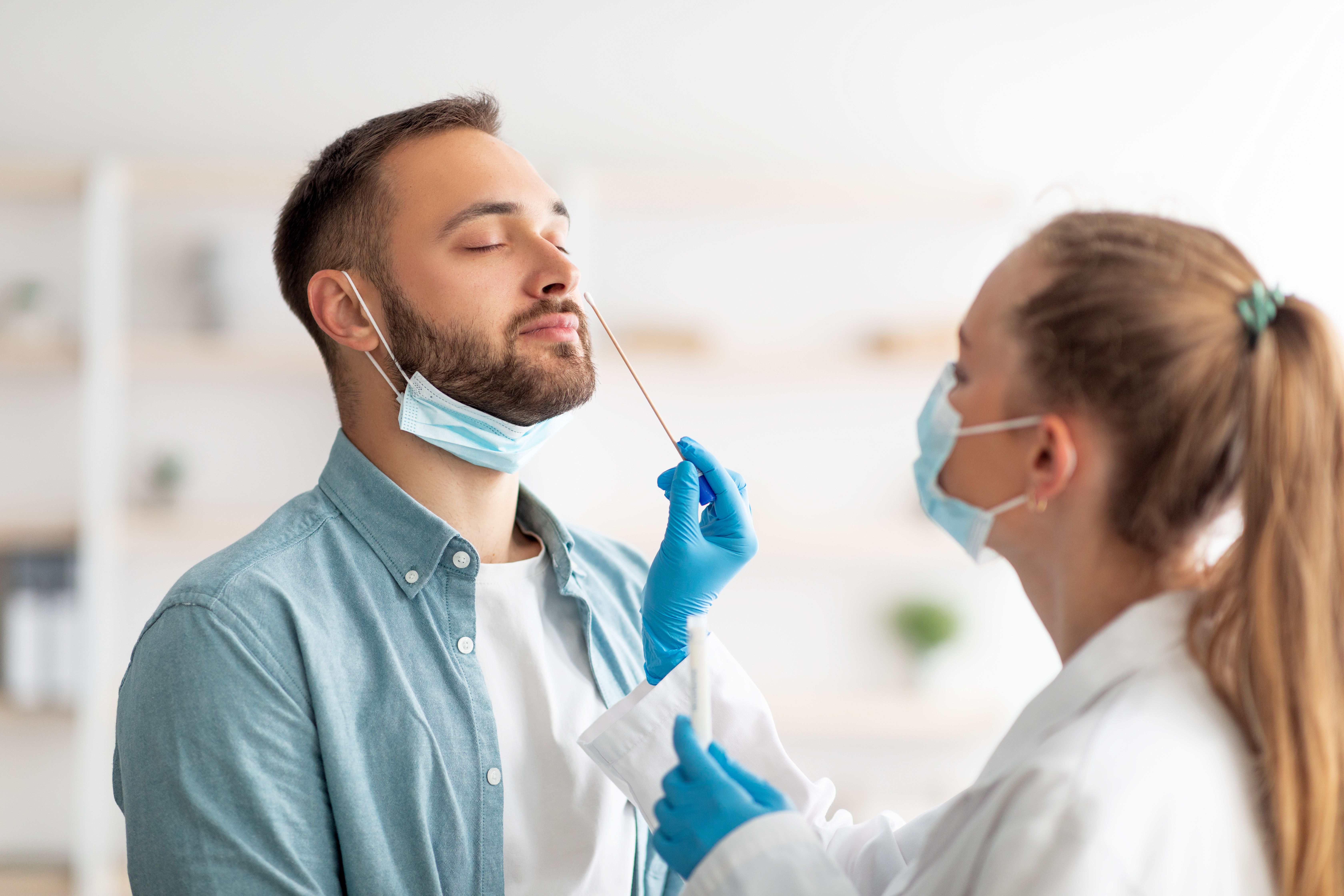 Health care professional performing a nasal COVID-19 test on a patient