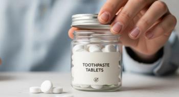 Person holding jar of toothpaste tablets on white countertop | Image Credit: Nataly | stock.adobe.com