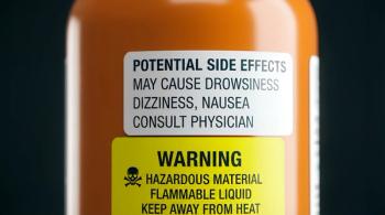 Close up on an orange pharmaceutical or chemical container label showing potential side effects and warning information like hazardous material and flammable liquid warnings warning label | Image Credit: Norah Allen | stock.adobe.com