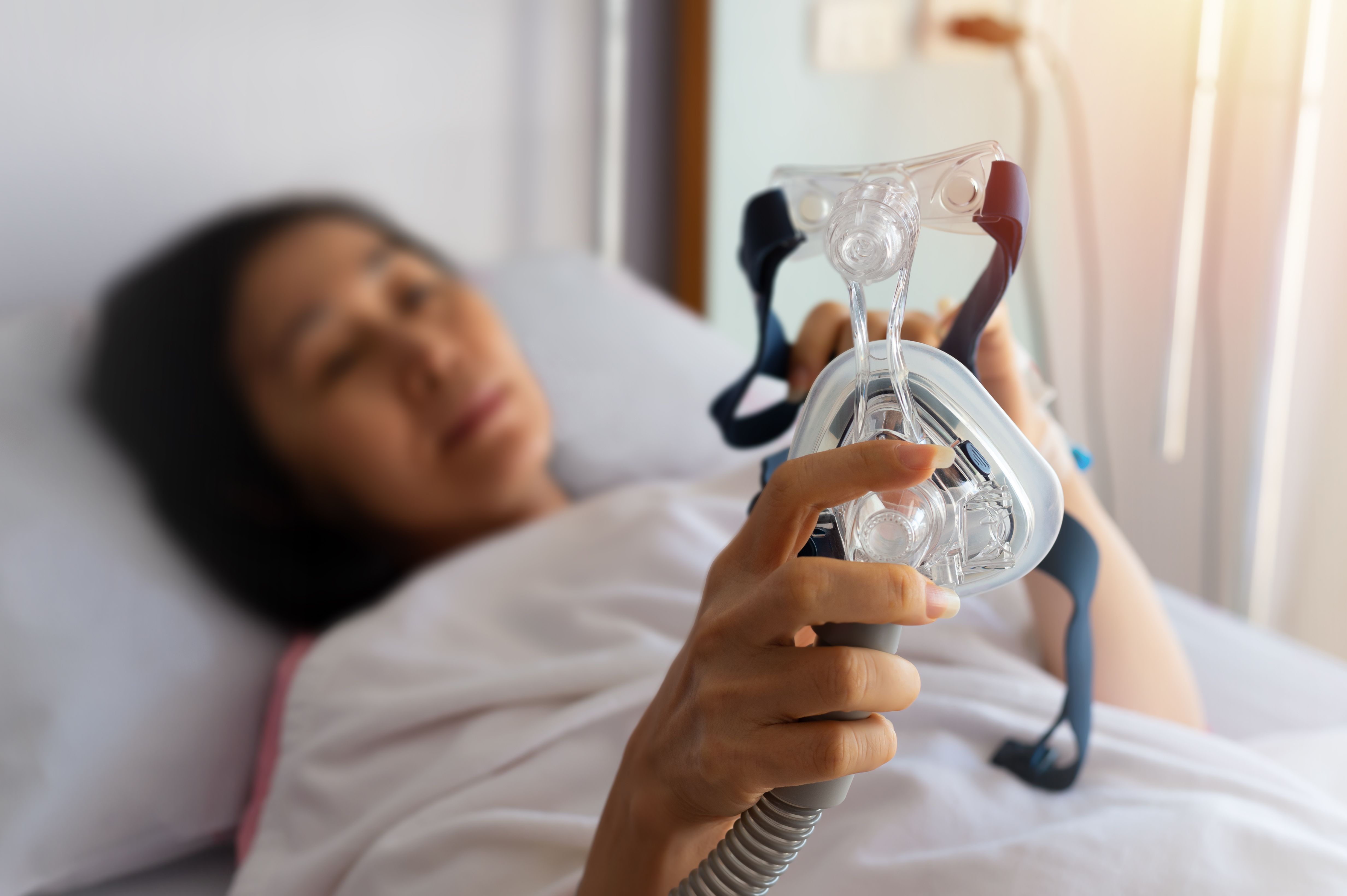 Woman holding CPAP mask | Image Credit: © sbw19 - stock.adobe.com