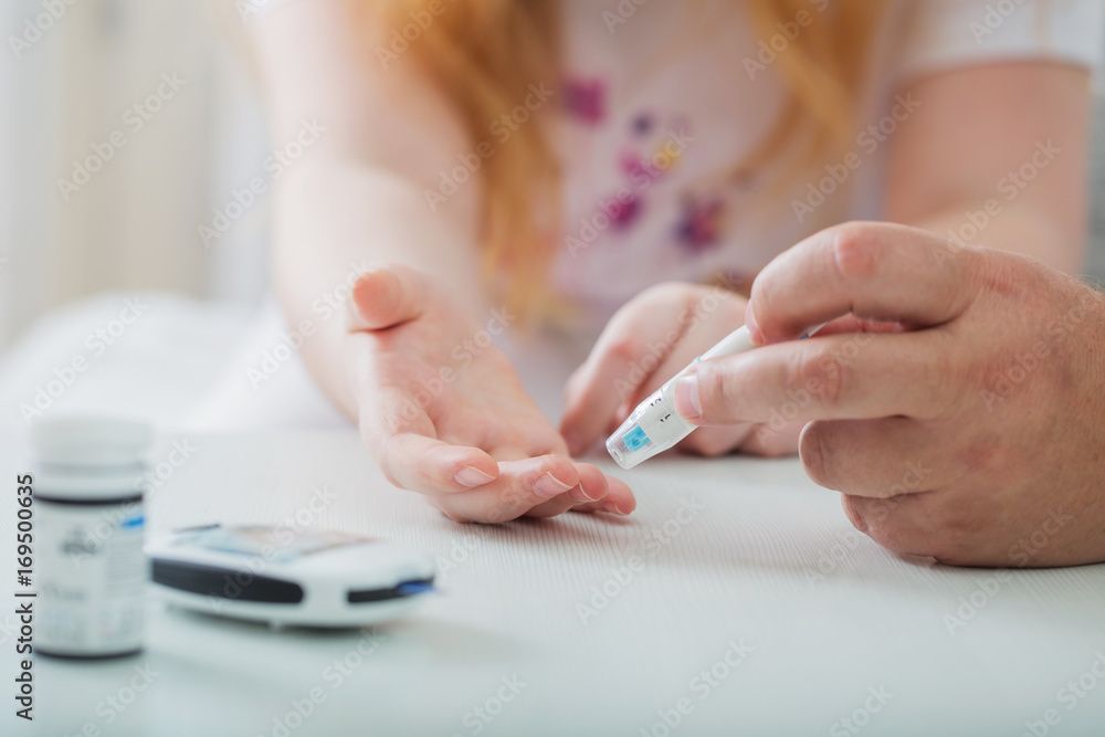 Measuring Blood Sugar Level Of Teen Girl With Glucometer | Image Credit: Maya Kruchancova - stock.adobe.com