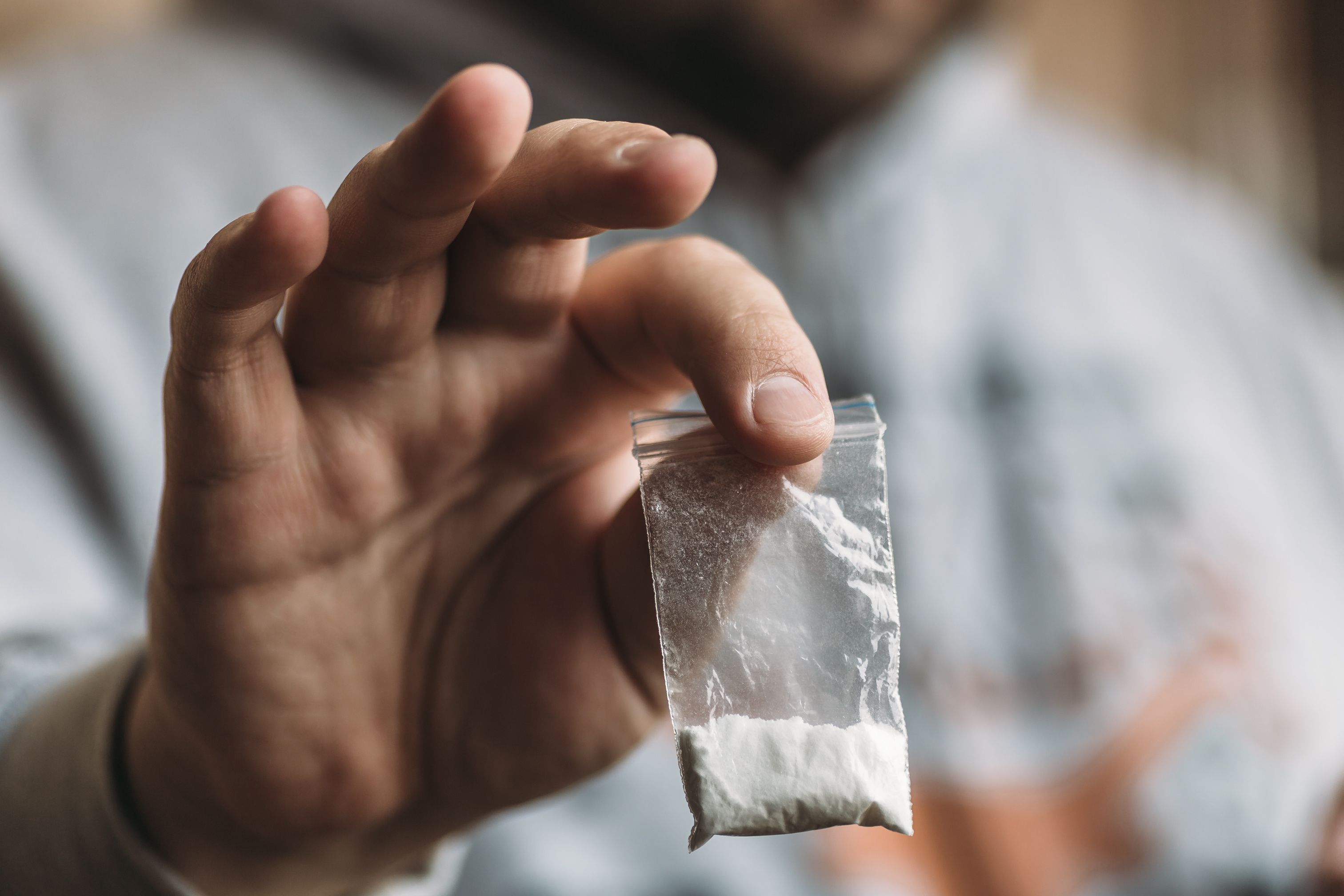 Man hand holding cocaine or other drugs, drug abuse - Image credit: DedMityay | stock.adobe.com