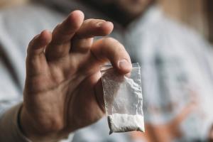 Man hand holding cocaine or other drugs, drug abuse - Image credit: DedMityay | stock.adobe.com