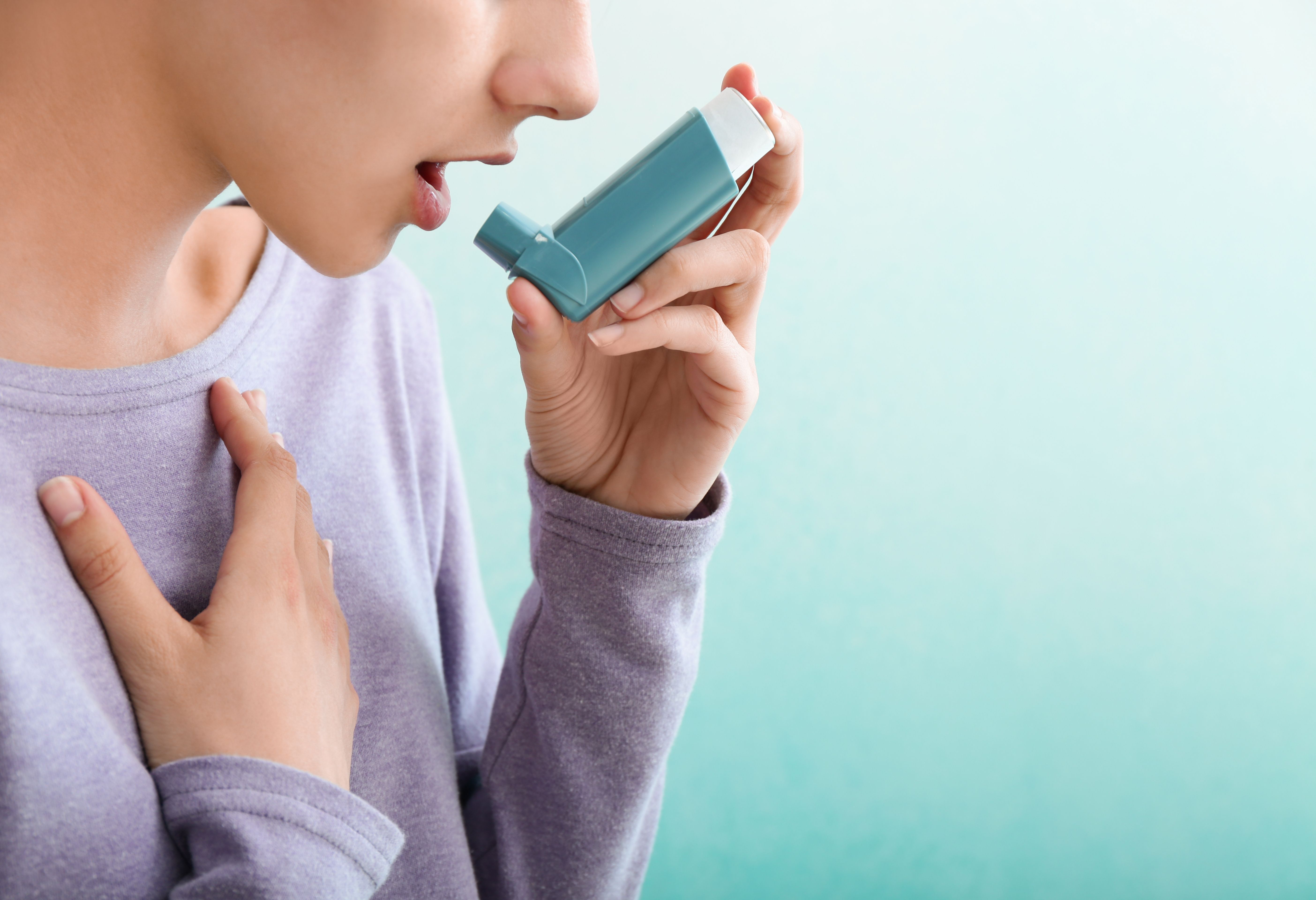 Woman using asthma inhaler -- Image credit: Pixel-Shot | stock.adobe.com
