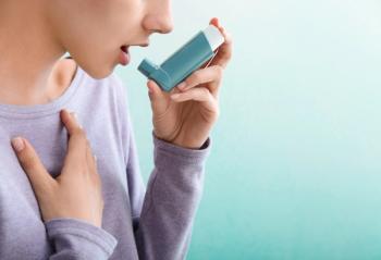 Woman using asthma inhaler -- Image credit: Pixel-Shot | stock.adobe.com