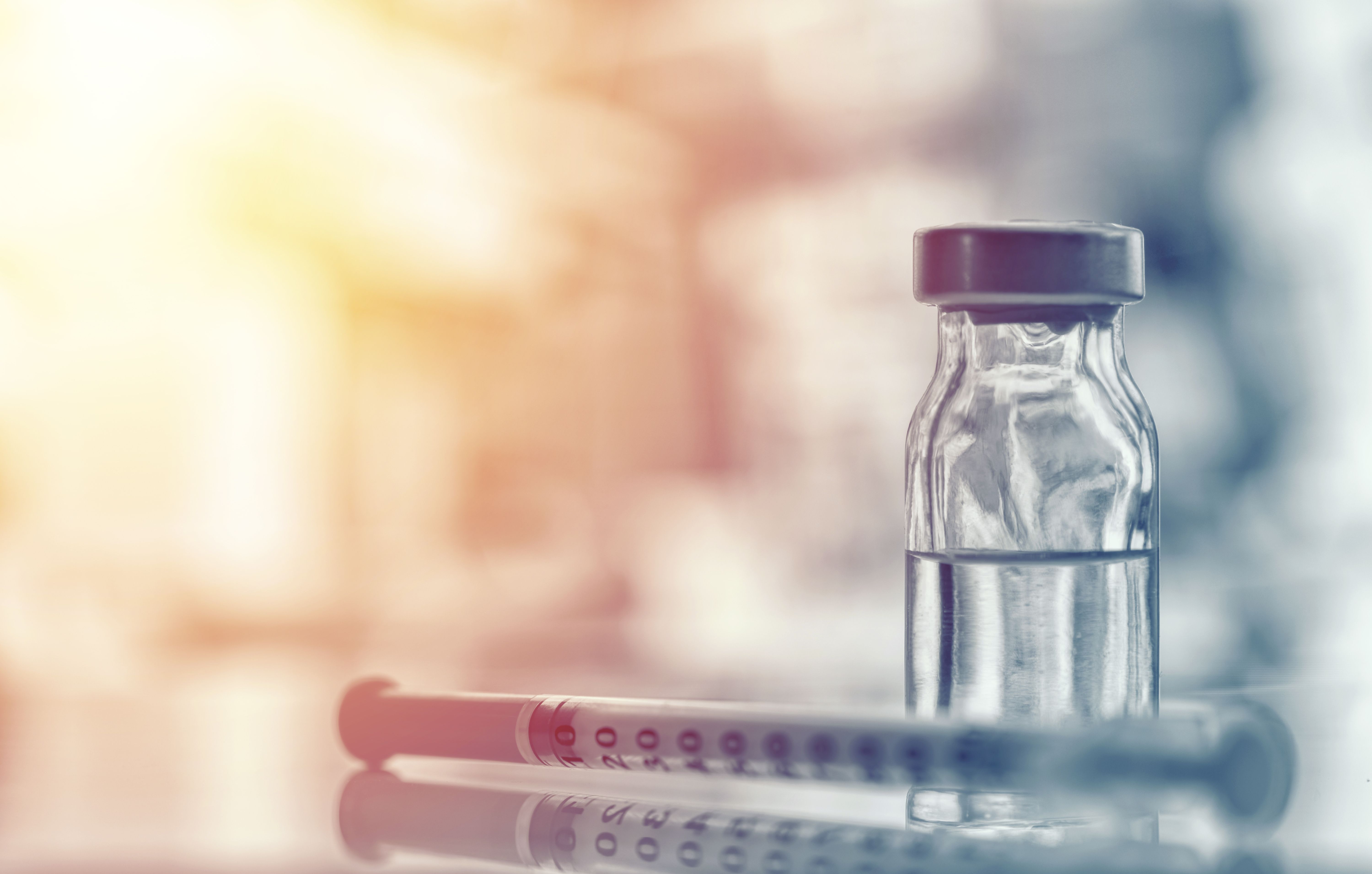 Closeup of medicine vial or flu, measles vaccine bottle with syringe and needle for immunization on vintage medical background, medicine and drug concept | Image Credit: Daniel CHETRONI - stock.adobe.com