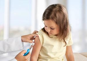 Female nurse giving an arm injection to a child. Little kid in getting a shot at a modern vaccination center. - Image credit: BillionPhotos.com | stock.adobe.com