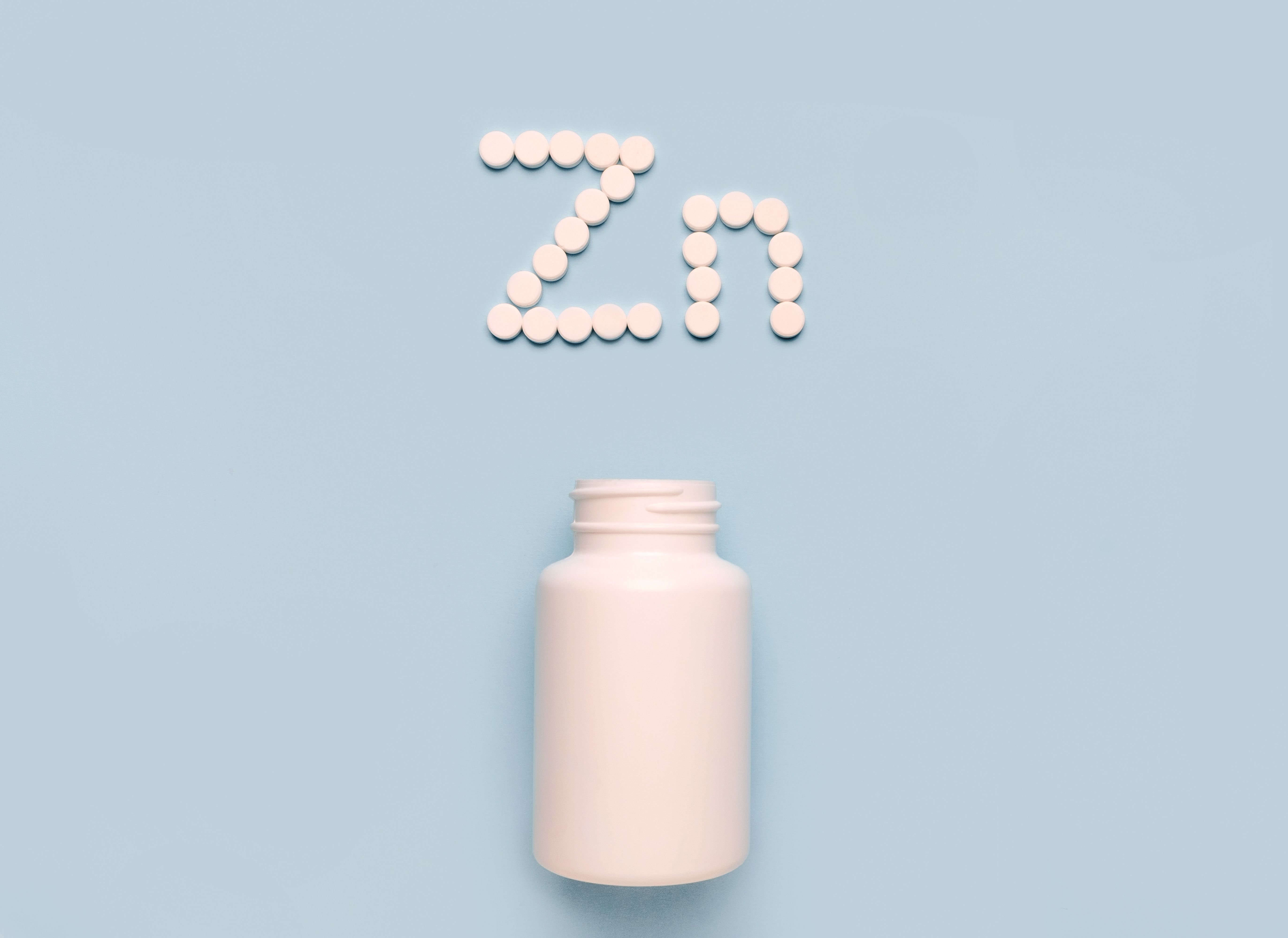 Chemical element Zinc Zn icon from tablets and drug bottle on blue background. Colltction of vitamin and minerals - Image credit: Iryna | stock.adobe.com