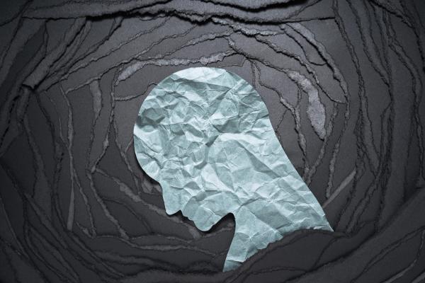 Silhouette of depressed and anxiety person head. Negative emotion image. Person head shaped paper on black torn paper background - Image credit: adamichi | stock.adobe.com
