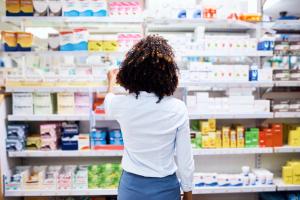 Back, pharmacy and medication with a woman customer buying medicine from a shelf in a dispensary. Healthcare, medical or treatment with a female consumer searching for a health product in a drugstor - Image credit: Arnell Koegelenberg/peopleimages.com | stock.adobe.com