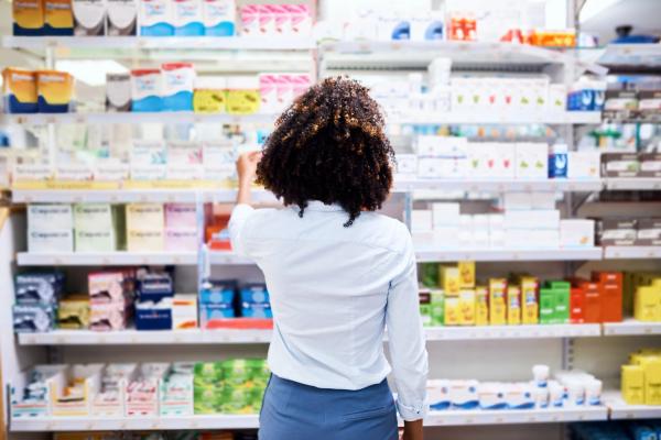 Back, pharmacy and medication with a woman customer buying medicine from a shelf in a dispensary. Healthcare, medical or treatment with a female consumer searching for a health product in a drugstor - Image credit: Arnell Koegelenberg/peopleimages.com | stock.adobe.com