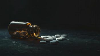 Close-Up of a Spilled Medicine Bottle with White Pills Posed Dramatically on a Dark Surface for Health and Wellness Imagery - Image credit: Gun | stock.adobe.com