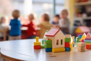Building bricks toys and blurry playing children in background in children day care center, kindergarten or preschool