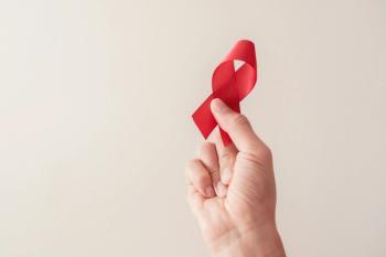 Man holding red ribbon for HIV awareness